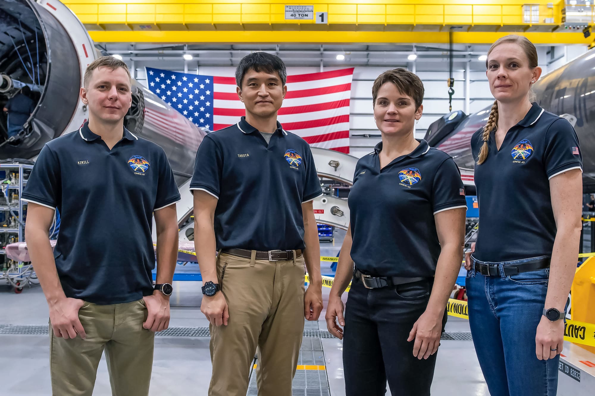 The Crew-10 crew inside SpaceX's booster refurbishment facility, Kirill Peskov (left) of Roscosmos, Takuya Onishi (center left) of JAXA, along with NASA Astronauts Anne McClain (center right) and Nichole Ayers (right). ©NASA/SpaceX