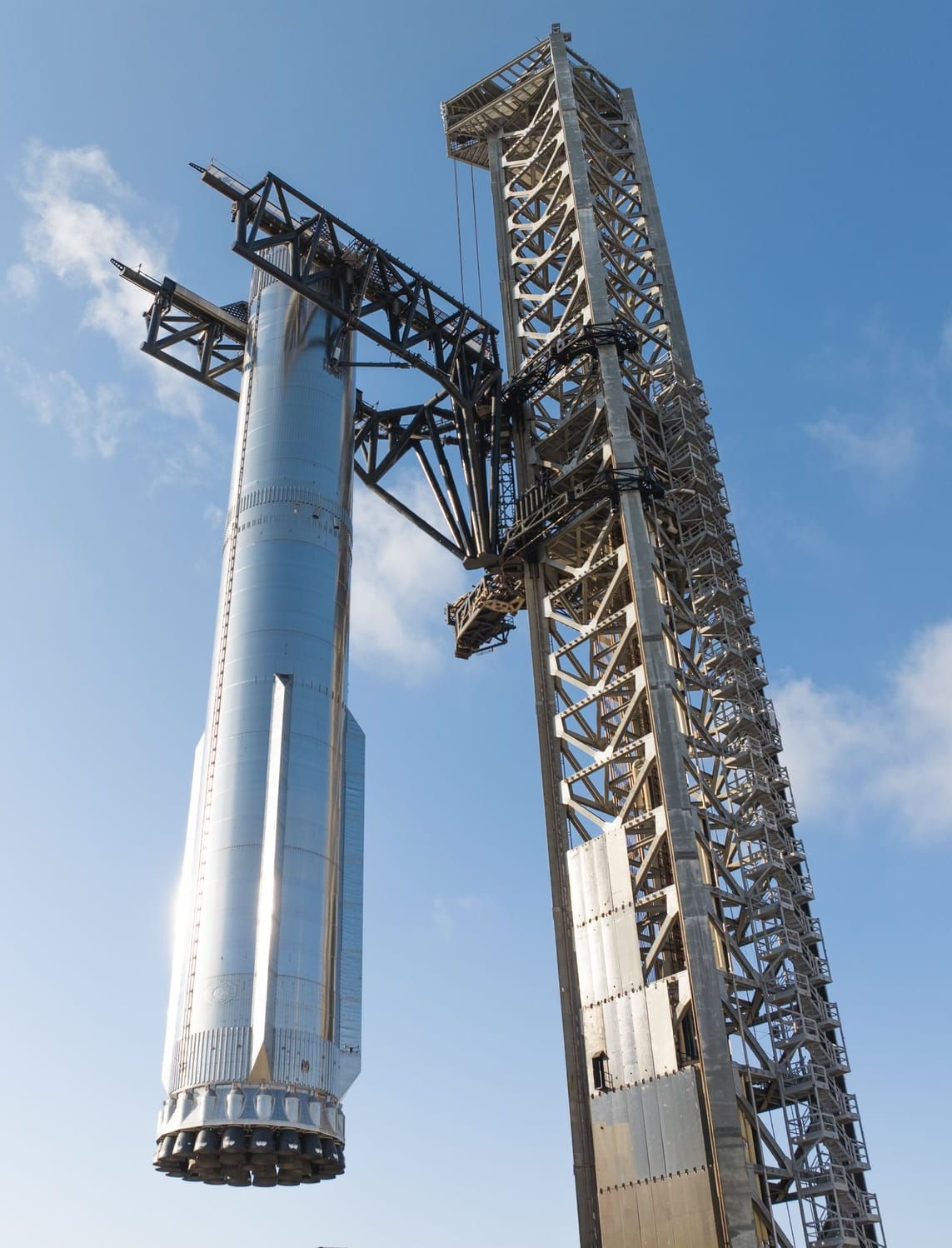 Super Heavy Booster 16 being lifted onto the launch pad by its towers 'chopsticks'. ©SpaceX