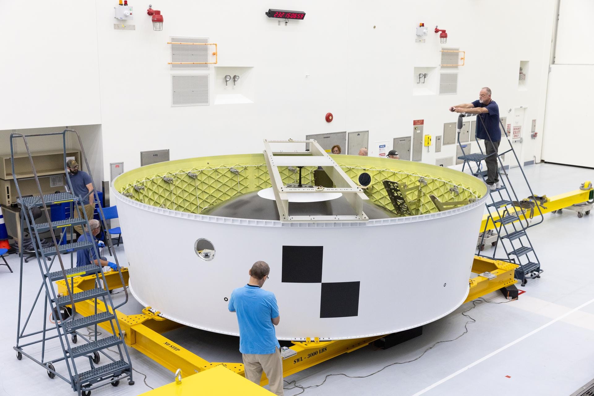 Technicians at the Kennedy Space Center inspect the Orion stage adapter, bound for Artemis II, after its arrival. ©Kim Shiflett/NASA