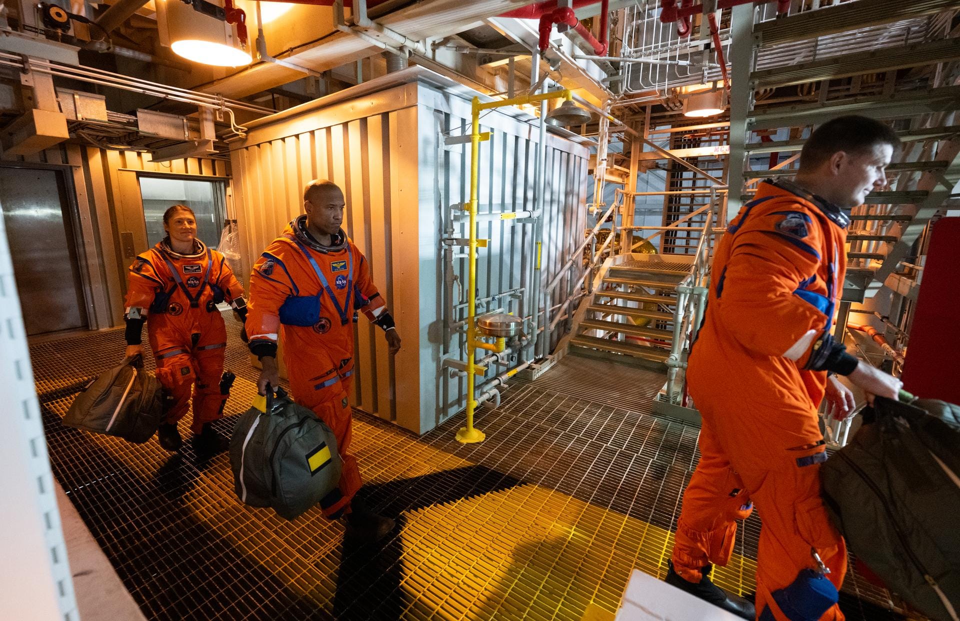 Artemis II astronauts Christina Koch (left), Victor Gover (center), and Jeremy Hansen (right) walking through the Mobile Launch Platform towards their Orion spacecraft. ©Joel Kowsky/NASA