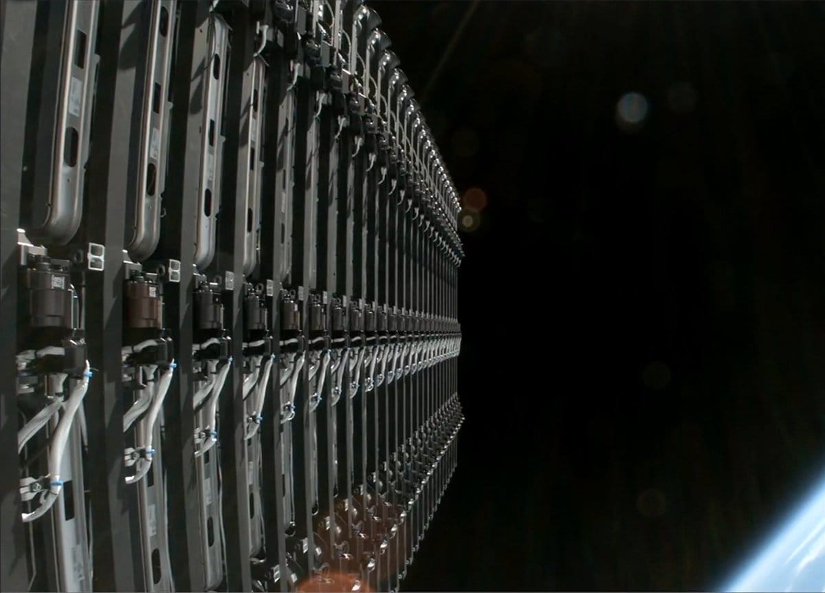 SpaceX's Starlink satellites await their deployment in orbit with a sliver of Earth in the bottom corner